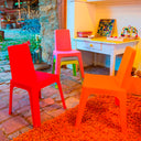 Conjunto Infantil Julieta con mesa naranja y 4 sillas multicolor para niños.